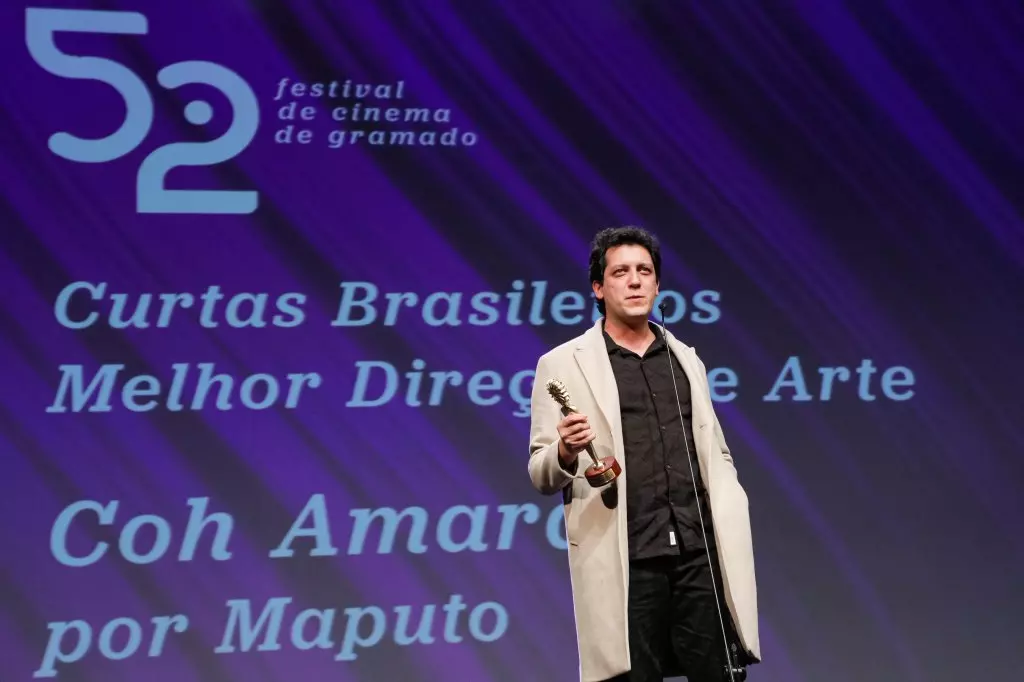 14439 | 17/08/2024 - 52º Festival de Cinema de Gramado - Coh Amaral recebe o prêmio de melhor direção de arte por “Maputo”, entregue por Érica Santos, marketing da Faixa Azul’ | Foto oficial: Cleiton Thiele/Agência Pressphoto