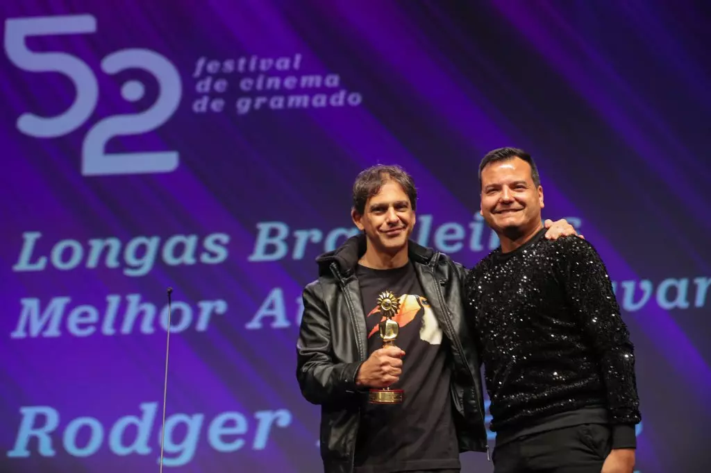 14517 | 17/08/2024 - 52º Festival de Cinema de Gramado - Rodger Rogério recebe o prêmio de melhor ator coadjuvante por “Oeste Outra Vez”, entregue por Roberson Guaraci Rocha dos Santos, coordenador de Marketing da Stemac Grupos Geradores | Foto oficial: Edison Vara/Agência Pressphoto