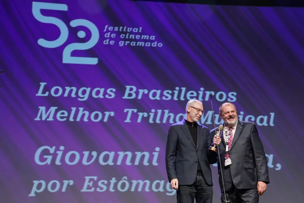 14944 | 17/08/2024 - 52º Festival de Cinema de Gramado - Giovanni Venosta recebe o prêmio de melhor trilha músical por “Estômago 2: O Poderoso Chef”, entregue por Jeferson Furstenau, diretora da Kia Sun Motors | Foto oficial: Cleiton Thiele/Agência Pressphoto