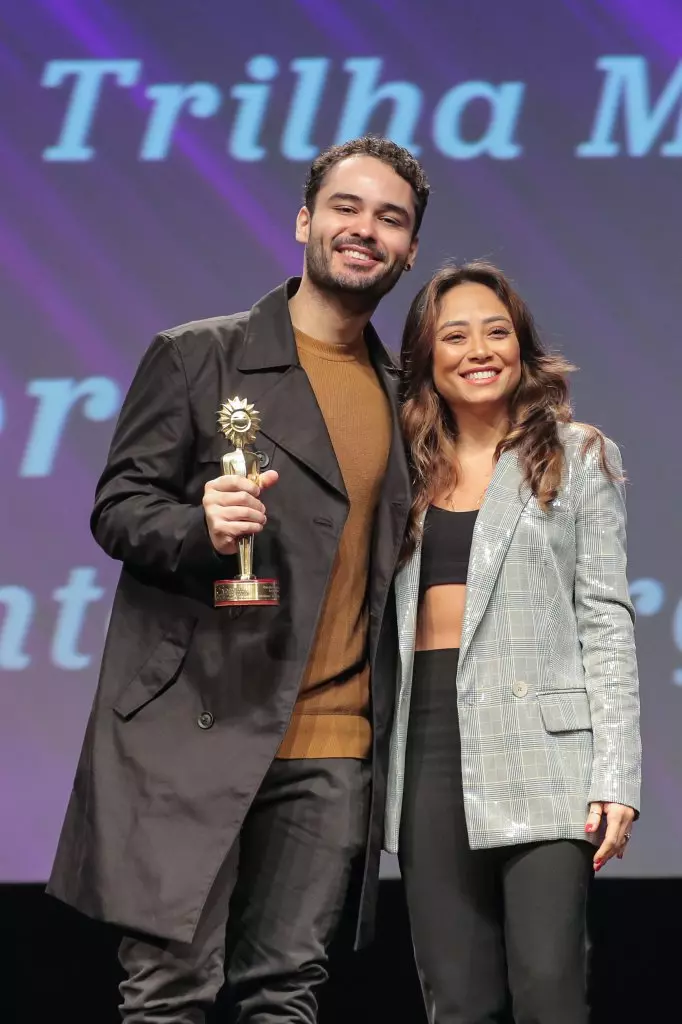 15870 | 17/08/2024 - 52º Festival de Cinema de Gramado - Liniker recebe o prêmio de melhor trilha sonora por “Ponto e Vírgula”, entregue por Mayumi Fugiwara, gerente nacional de eventos Johnnie Walker | Foto oficial: Edison Vara/Agência Pressphoto